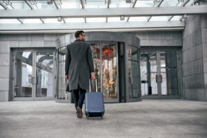 people-and-technology-concept-happy-young-man-with-travel-bag-rear-view